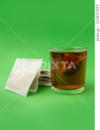 Herbal tea sachet in glass, hot water with chamomile and Hypericum or St. John's wort teabag 123672935
