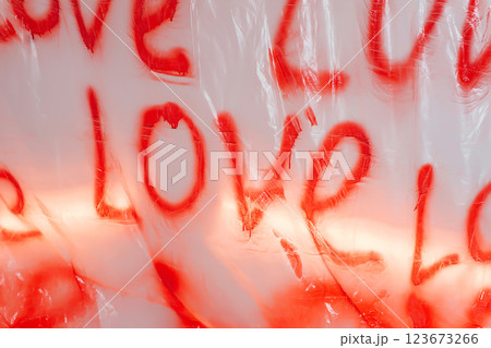 love inscription on a plastic bag with red spray paint. photo zone for March 8 love inscription on a plastic bag with red spray paint. photo zone for March 8 123673266