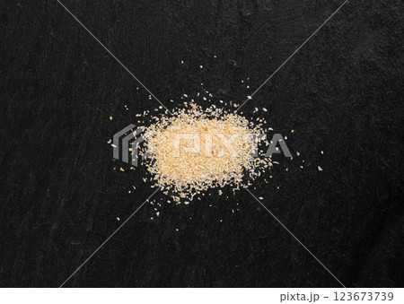 Garlic powder pile, dried granulated chopped crushed garlic cloves, cut into small pieces 123673739