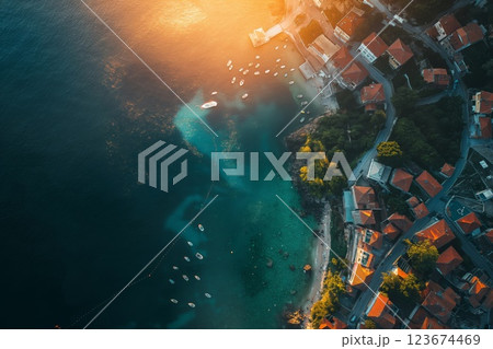 Warm sunlight bathes a picturesque coastal town and azure waters at dusk 123674469