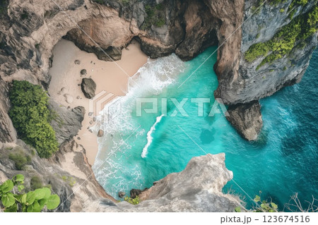 Stunning top-down view of a hidden beach surrounded by rugged cliffs and lush greenery 123674516