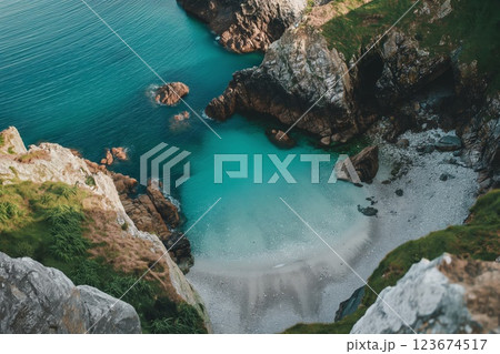Aerial view of a hidden beach with turquoise sea, surrounded by rugged cliffs Aerial view of a hidden beach with turquoise sea, surrounded by rugged cliffs 123674517