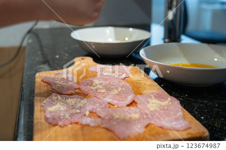 Peppering of tenderized meat for schnitzel Peppering of tenderized meat for schnitzel 123674987