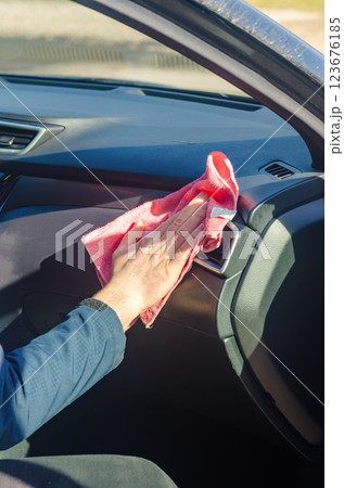 Hand wiping car dashboard with a microfibre cloth. High quality photo 123676185