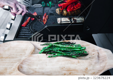 asparagus on wooden plate. . Delicious grilled vegetables asparagus on barbecue grill with smoke and flame. asparagus on wooden plate. . Delicious grilled vegetables asparagus on barbecue grill with smoke and flame. 123676224