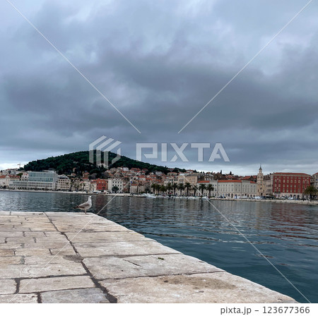 Split pier overlooking the old town and promenade on a cloudy day. 123677366