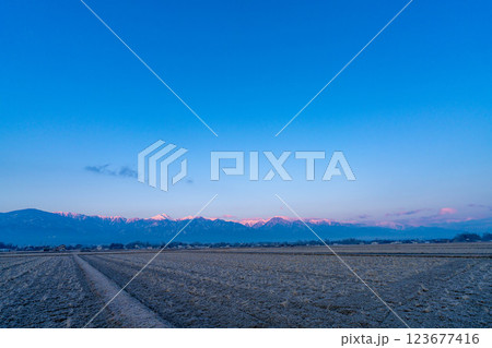 【北アルプス素材】冬の安曇野市内から見る朝焼けに染まる北アルプス【長野県】 123677416