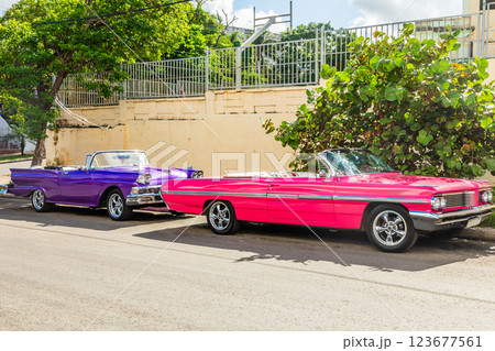 Old american pink and violet retro luxury cars parked in the center of old Havana, Cuba Old american pink and violet retro luxury cars parked in the center of old Havana, Cuba 123677561