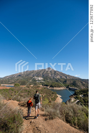 Father and son hiking in scenic mountain landscape under clear blue sky, La Concepcion reservoir in Father and son hiking in scenic mountain landscape under clear blue sky, La Concepcion reservoir in 123677892