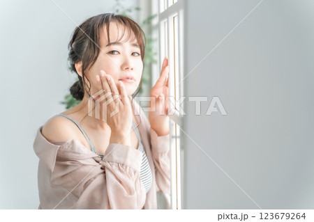 朝窓際に立つアジア人女性の美容イメージ(日光浴・スキンケア・紫外線) 朝窓際に立つアジア人女性の美容イメージ(日光浴・スキンケア・紫外線) 123679264
