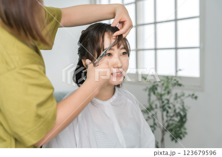 美容室・美容院・ヘアサロンで施術を受ける女性と美容師 123679596