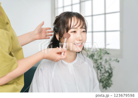 メイクさんにメイクされる女性(メイキャップアーティスト・メイクさん・美容部員・美容師) メイクさんにメイクされる女性(メイキャップアーティスト・メイクさん・美容部員・美容師) 123679598
