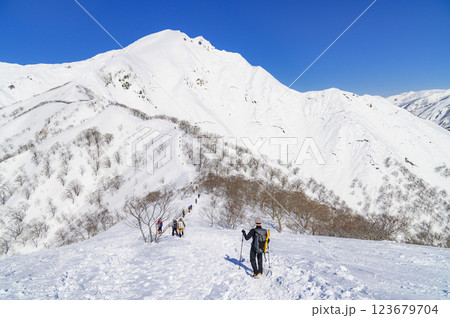 雪山登山・谷川岳天神尾根の絶景と登る登山者 123679704