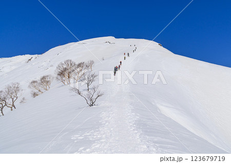 雪山登山・谷川岳天神尾根の絶景と登る登山者 雪山登山・谷川岳天神尾根の絶景と登る登山者 123679719