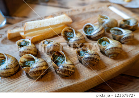 Escargot platter with herb butter and toasted bread on wooden board Escargot platter with herb butter and toasted bread on wooden board 123679727