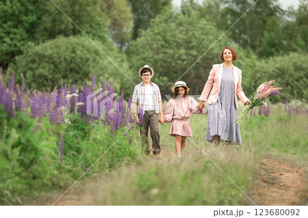 Happy caucasian family walking in flower field with children in summer 123680092