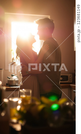 A married couple hugs in the morning in the kitchen. A man and a woman in love hugging each other in the rays of the morning sun 123681149