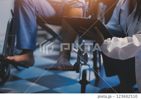 Asian young professional successful friendly female nurse in blue hospital uniform helping supporting physical therapy senior old pensioner unhealthy injury woman patient walking via four legs walker. Asian young professional successful friendly female nurse in blue hospital uniform helping supporting physical therapy senior old pensioner unhealthy injury woman patient walking via four legs walker. 123682510