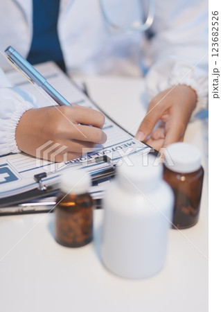 Doctor sitting at desk and writing a prescription for her patient Doctor sitting at desk and writing a prescription for her patient 123682526