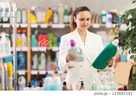 Adult woman buyer chooses detergent in store 123683181