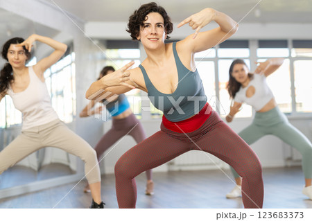 Emotional Latina rehearsing popping techniques during group workout 123683373