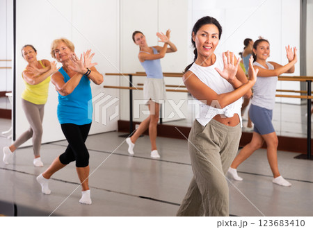 Group of active women practicing energetic dance in a studio Group of active women practicing energetic dance in a studio 123683410