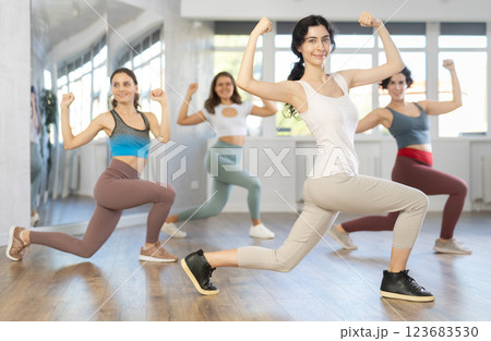 Emotional female dancer rehearsing popping techniques during group workout Emotional female dancer rehearsing popping techniques during group workout 123683530