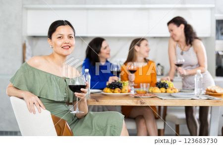 Happy Kazakh girl sitting in front of friends group, with her back to speakers. Happy Kazakh girl sitting in front of friends group, with her back to speakers. 123683730