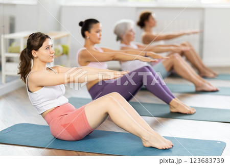 Young woman doing pilates in group Young woman doing pilates in group 123683739