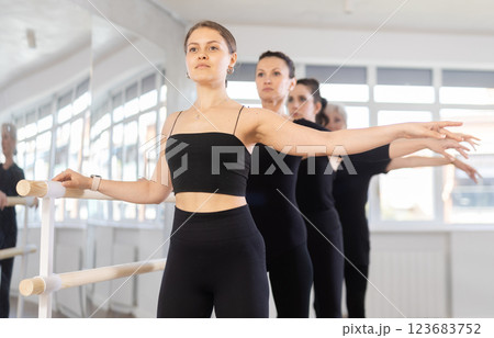 Young female ballerina performing second position at ballet barre Young female ballerina performing second position at ballet barre 123683752