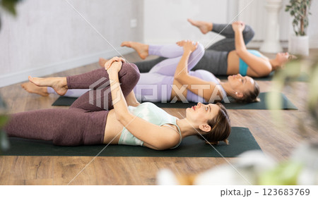 Three women doing yoga in fitness studio Three women doing yoga in fitness studio 123683769