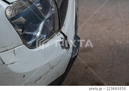 The front bumper of a white car with numerous minor injuries in form of scratches, chips, tears. Minor road traffic accidents that impair the integrity of the protective paint on the hull elements The front bumper of a white car with numerous minor injuries in form of scratches, chips, tears. Minor road traffic accidents that impair the integrity of the protective paint on the hull elements 123683838