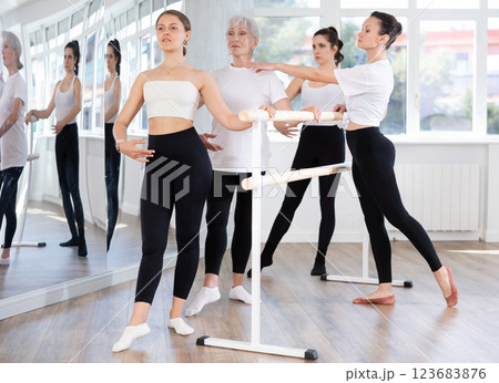 Girl performing battement tendu during group barre fitness workout 123683876