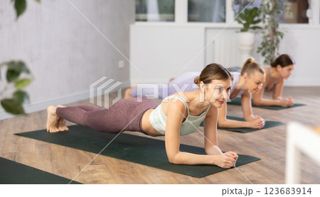 Young woman practicing plank pose in yoga studio 123683914
