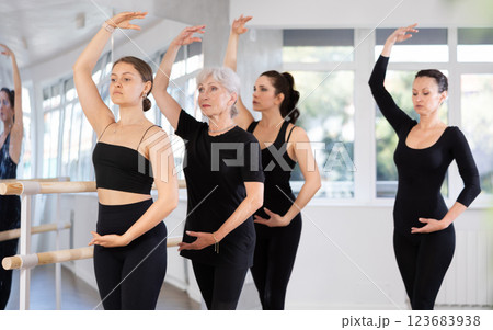 Fit young woman performing fourth position during ballet training 123683938