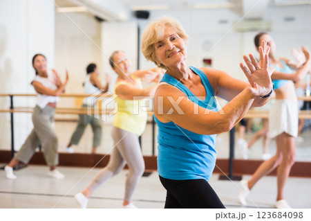 Portrait of mature woman practicing ballet dance moves during group class in choreographic studio Portrait of mature woman practicing ballet dance moves during group class in choreographic studio 123684098
