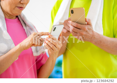 運動後にスマホを見て結果を気にするシニア男女 運動後にスマホを見て結果を気にするシニア男女 123684292