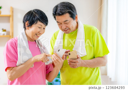 運動後にスマホを見て結果を気にするシニア男女 123684293