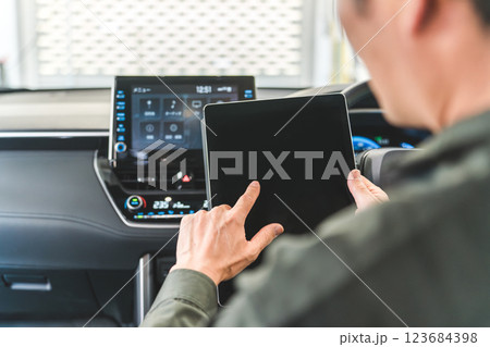 自動車の車内でタブレットを使い・メンテナンス・修理・チェック・点検する男性作業員 123684398