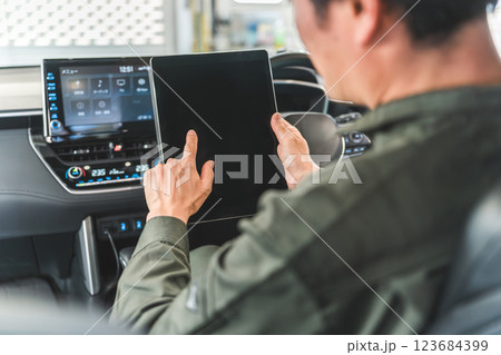 自動車の車内でタブレットを使い・メンテナンス・修理・チェック・点検する男性作業員 123684399