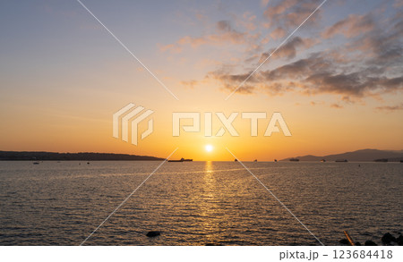 Sunset time at English Bay Beach and ships parked on the ocean. Vancouver City beautiful landscape. British Columbia, Canada. Sunset time at English Bay Beach and ships parked on the ocean. Vancouver City beautiful landscape. British Columbia, Canada. 123684418