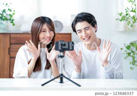 笑顔で動画撮影をする男女 123686337