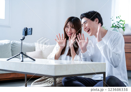 笑顔で動画撮影をする男女 123686338