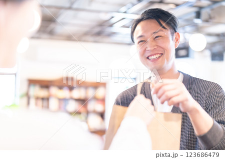 商品をお渡しする笑顔の飲食店の店員 123686479