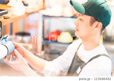 カフェで働く若いバリスタ店員 123686482