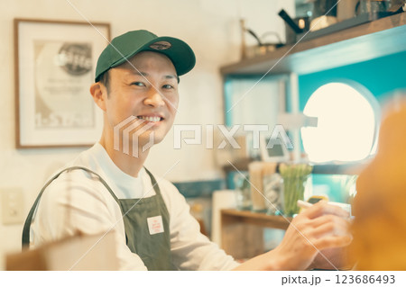カフェで働く若いバリスタ店員 123686493