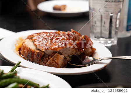 crispy pork and roasted duck is served with a caramelized glaze, embodying authentic Chinese barbecue flavors. 123686661