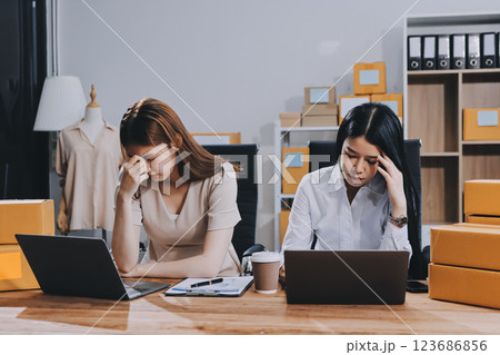 Startup SME small business entrepreneur of freelance Asian woman using a laptop with box Cheerful success Asian woman her hand lifts up online marketing packaging box and delivery SME idea concept Startup SME small business entrepreneur of freelance Asian woman using a laptop with box Cheerful success Asian woman her hand lifts up online marketing packaging box and delivery SME idea concept 123686856