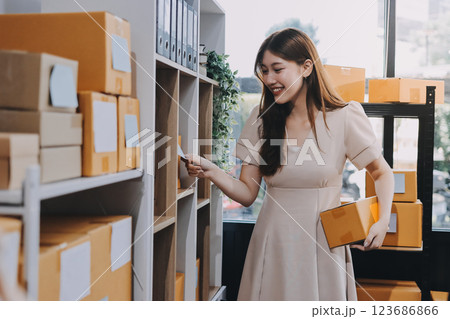 Asian SME business women use laptop computer checking customer order online shipping boxes at home. Starting Small business entrepreneur SME freelance. Online business, Work at home concept. Asian SME business women use laptop computer checking customer order online shipping boxes at home. Starting Small business entrepreneur SME freelance. Online business, Work at home concept. 123686866