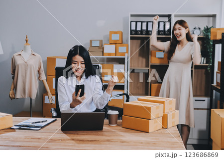 Asian SME business women use laptop computer checking customer order online shipping boxes at home. Starting Small business entrepreneur SME freelance. Online business, Work at home concept. 123686869